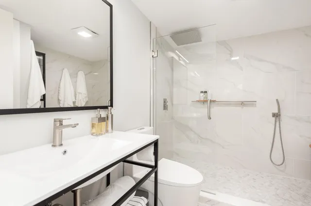 a bathroom with a sink a toilet and shower