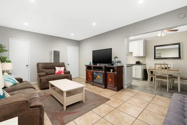 a living room with furniture a potted plant and a table