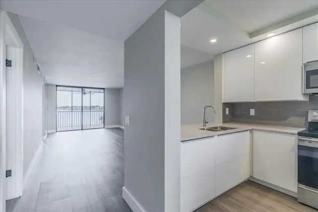 a kitchen with a sink cabinets and wooden floor