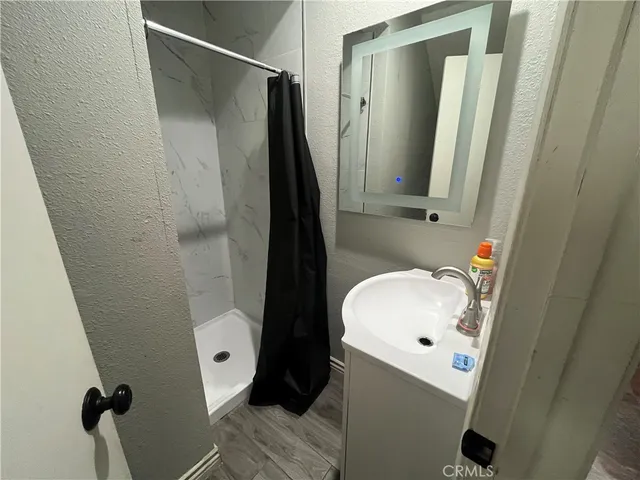 a bathroom with a sink and mirror with toilet