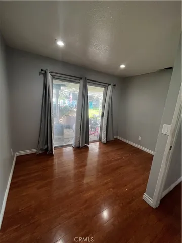an empty room with wooden floor and a window