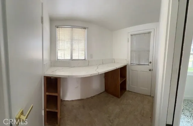 a room with a sink cabinets and a window