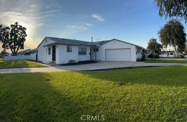 a front view of a house with a yard and trees
