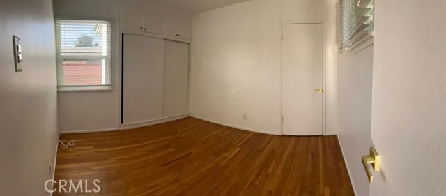 a view of a room with wooden floor and white walls