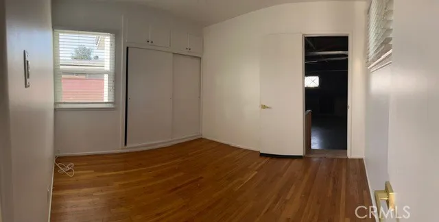 a view of an empty room with closet and a window