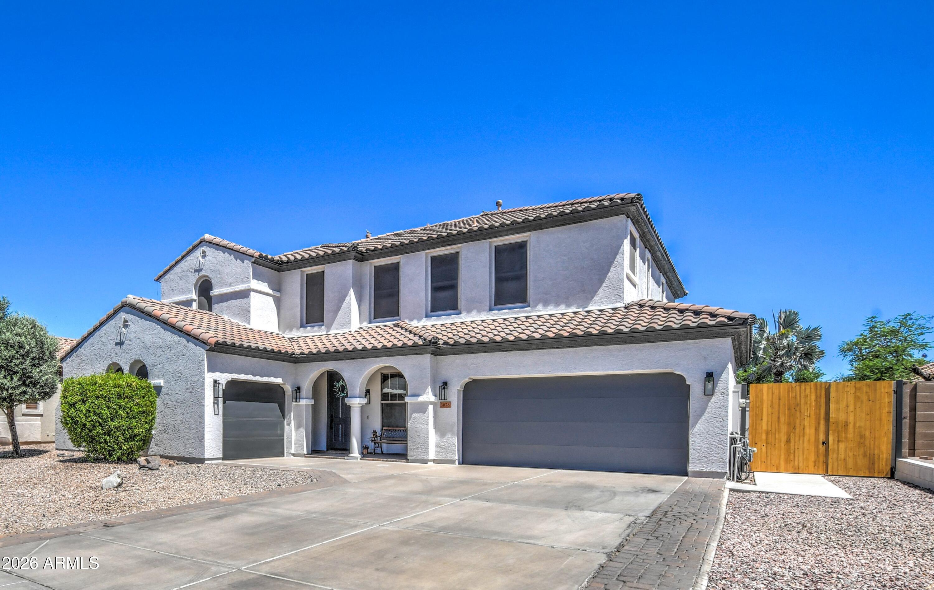 3078 East Muirfield Street Gilbert, AZ 85298 - Photo 6 of 92 a front view of a house with a garden