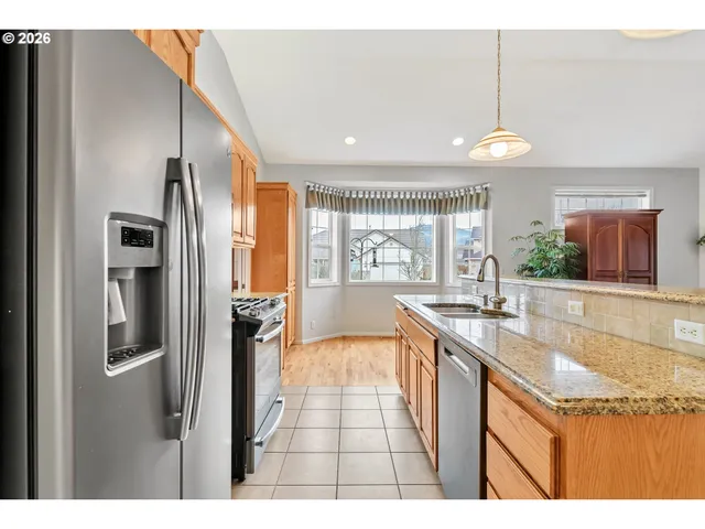a kitchen with stainless steel appliances granite countertop a sink and a refrigerator