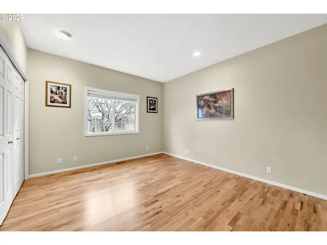 a view of an empty room with window and closet