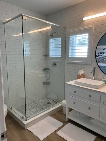 a bathroom with a shower sink and mirror