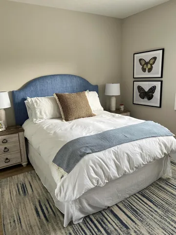 a bedroom with a bed and painting on the wall