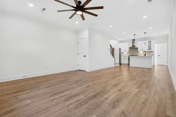 a view of empty room with wooden floor and window