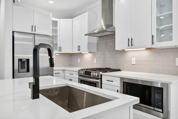 a kitchen with granite countertop a stove and a sink
