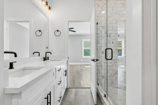 a spacious bathroom with a double vanity sink a mirror a shower and a bathtub
