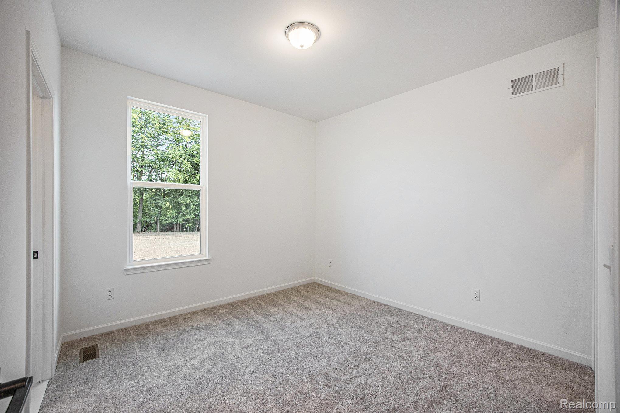 68788 Place Road New Haven, MI 48050 - Photo 8 of 29 Spare room featuring light carpet and baseboards