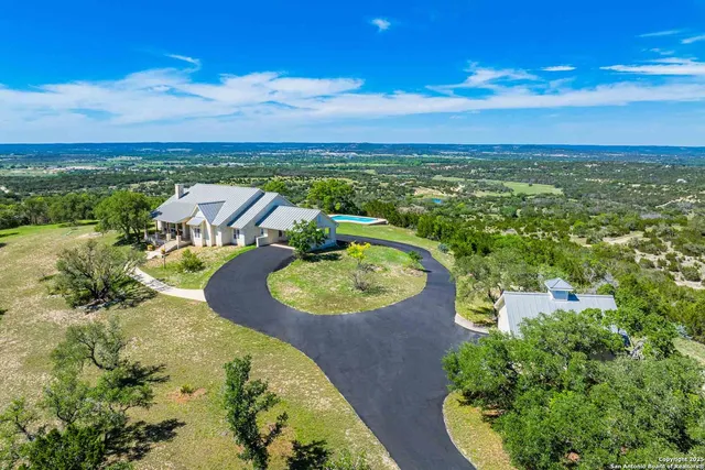 an aerial view of a swimming pool with a yard
