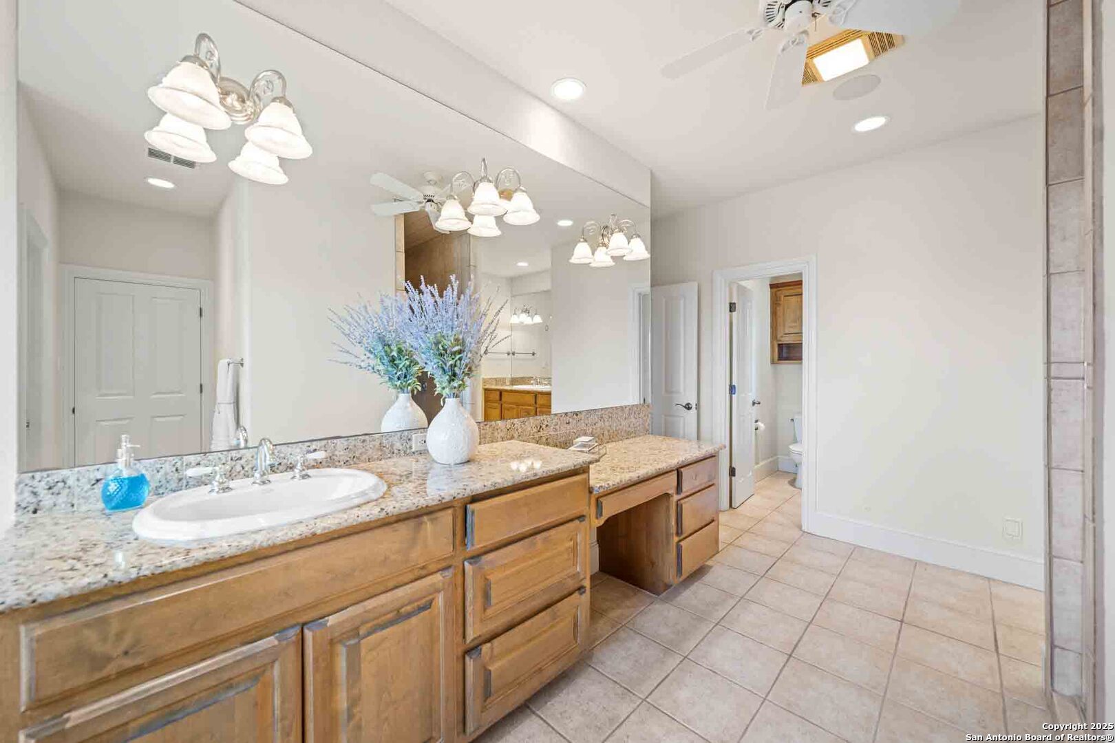 211 Mill Dam Road Comfort, TX 78013 - Photo 25 of 61 a spacious bathroom with a granite countertop sink a toilet and a mirror