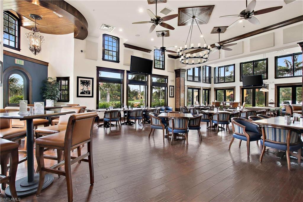 9076 Rialto Street, Unit 6204 Naples, FL 34113 - Photo 38 of 50 The Ole Pub features spacious dining area with wood flooring, numerous windows, decorative ceiling fans, and a large central chandelier