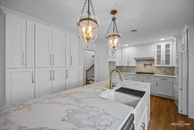 a kitchen with granite countertop white cabinets and white appliances