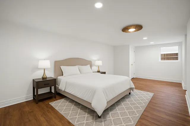 a view of an empty room with wooden floor and window