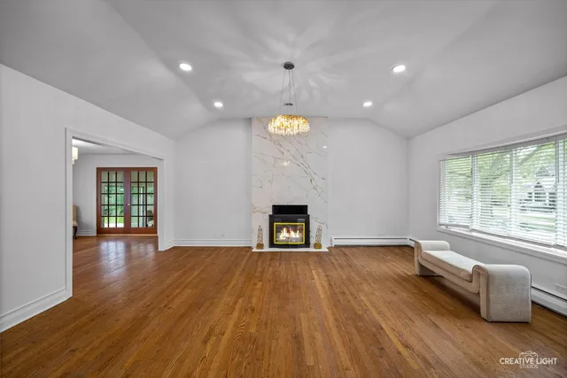 a view of empty room with wooden floor and fireplace