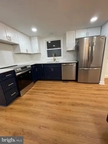 a kitchen with stainless steel appliances granite countertop a refrigerator a stove a sink and a microwave