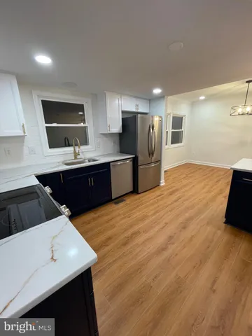 a kitchen with stainless steel appliances a sink dishwasher stove refrigerator and cabinets