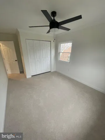 an empty room with a window and a ceiling fan