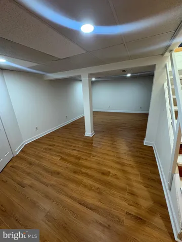 a view of a room with wooden floor and ceiling fan