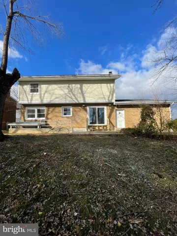a view of a house with backyard and parking area