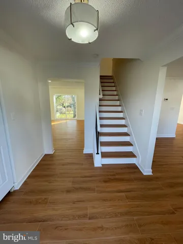 a view of entryway and hall with wooden floor