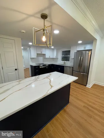 a large kitchen with stainless steel appliances a large counter top