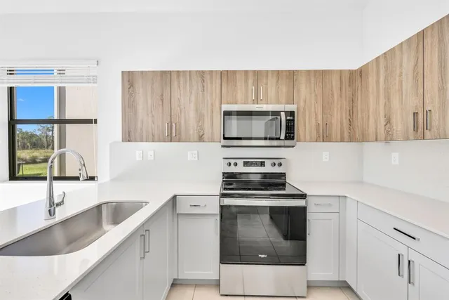 a kitchen with stainless steel appliances granite countertop a sink and a wooden cabinets