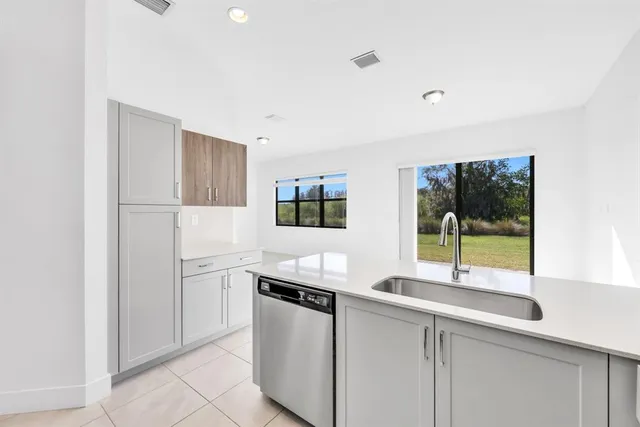 a large white kitchen with a white stove top oven and white cabinets