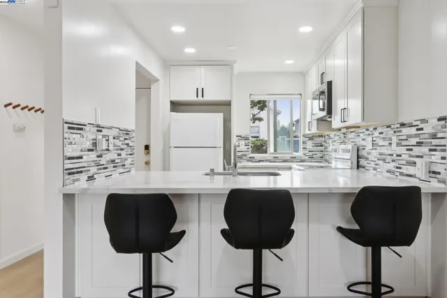 a kitchen with granite countertop a counter space a sink appliances and cabinets