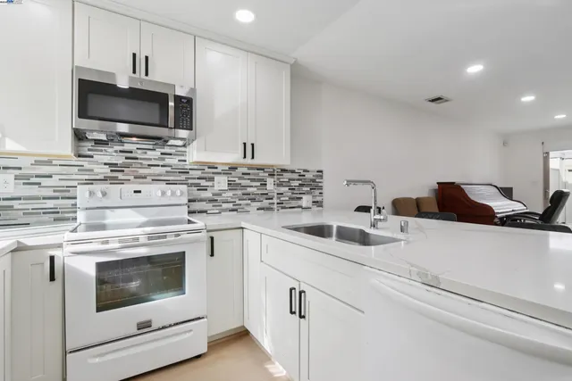 a kitchen with appliances a sink and cabinets
