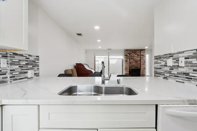 a kitchen with a sink and a stove top oven with wooden floor
