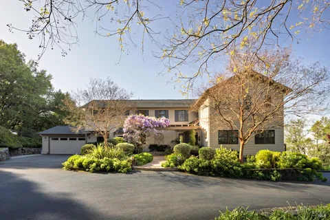 a front view of a house with a lot of flower plants