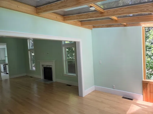 a view of an empty room with a fireplace and a window