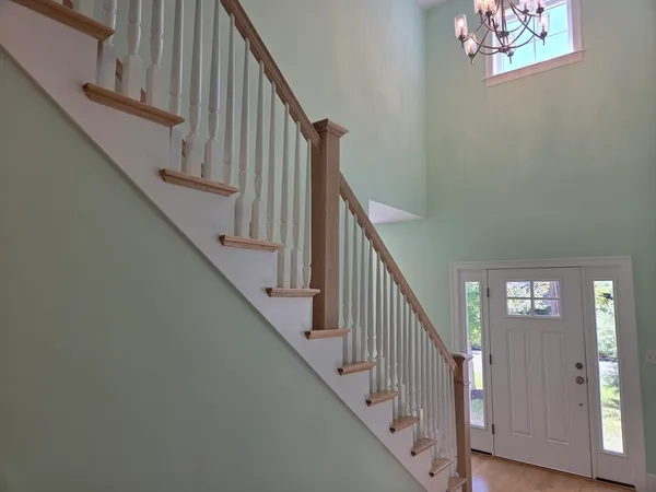 a view of staircase with lots of frames on wall and wooden floor