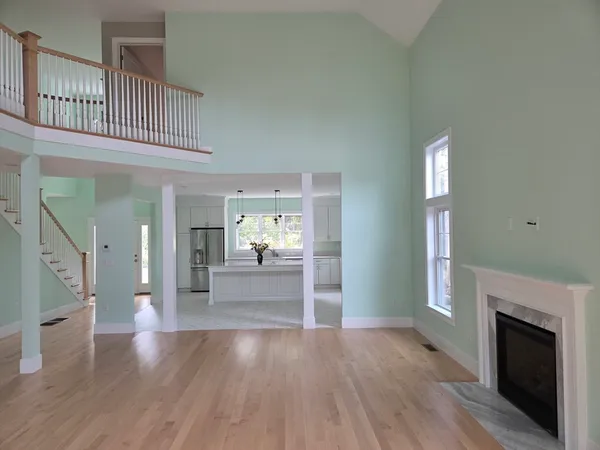 a view of a hallway view with wooden floor and a fireplace