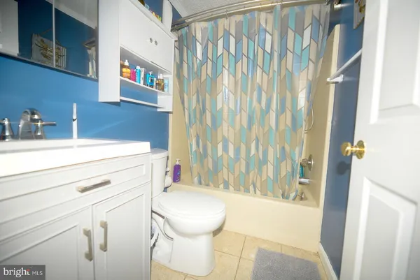 a bathroom with a sink a toilet and shower curtain