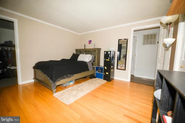 a bedroom with a bed and wooden floor