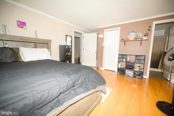 a spacious bedroom with a bed and a flat screen tv