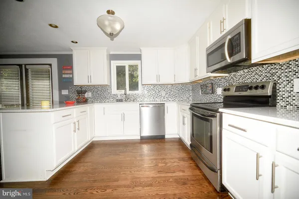 a kitchen with granite countertop a stove top oven sink and cabinets