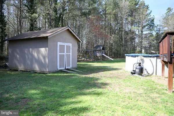 a view of a backyard with a barn and a large tree