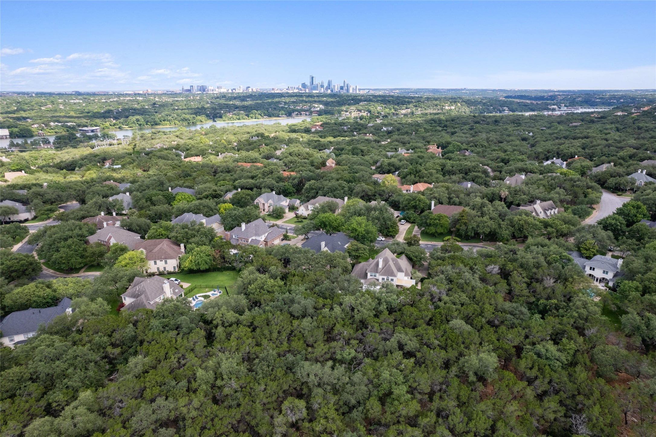 4313 Rio Robles Drive Austin, TX 78746 - Photo 39 of 40 An aerial perspective reveals a verdant neighborhood with glimpses of downtown city views and a meandering river.