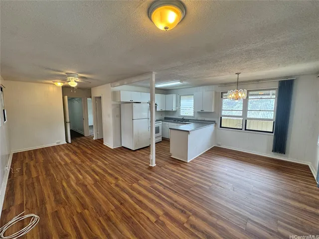 a view of a kitchen with wooden floor and a window