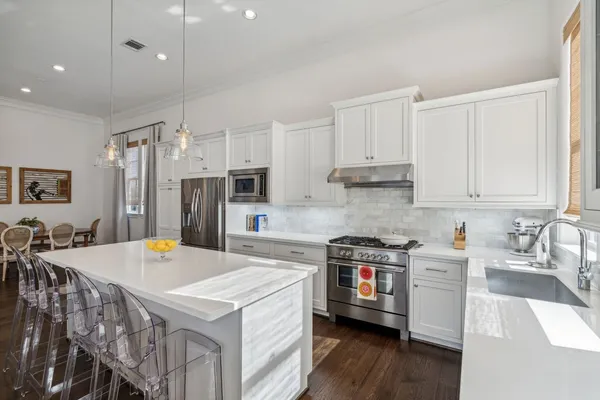 a kitchen that has a lot of cabinets a sink and a stove in it