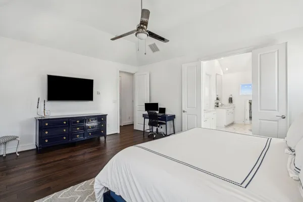 a bedroom with a bed and a flat tv screen on a dresser