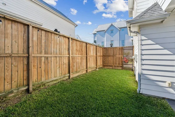 a view of a backyard with wooden fence